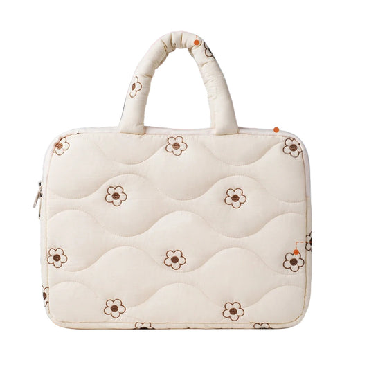 White quilted laptop bag with floral patterns on a blurred office background